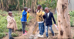 Haven of Hope Intl, Watu Wa Maana boys brush their teeth over a stream