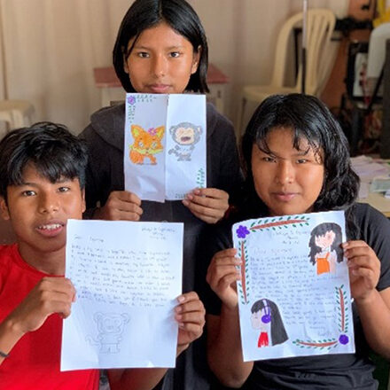 Siblings Javier, Erika and Reynilda display letters they wrote.